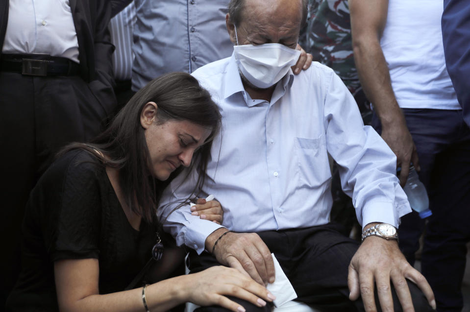 The father, right, and the sister, left, of Charbel Karam, one of the ten firefighters who were killed during the Aug. 4 explosion that hit the seaport of Beirut, mourn during his funeral at the firefighter headquarters, in Beirut, Lebanon, Monday, Aug. 17, 2020. (AP Photo/Hussein Malla)