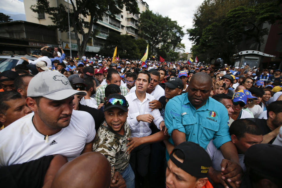 The leader of Venezuela's National Assembly Juan Guaido, center, who declared himself the country's interim president, walks with supporters during a rally against the government of President Nicolas Maduro in Caracas, Venezuela, Saturday, March 9, 2019. (AP Photo/Eduardo Verdugo)