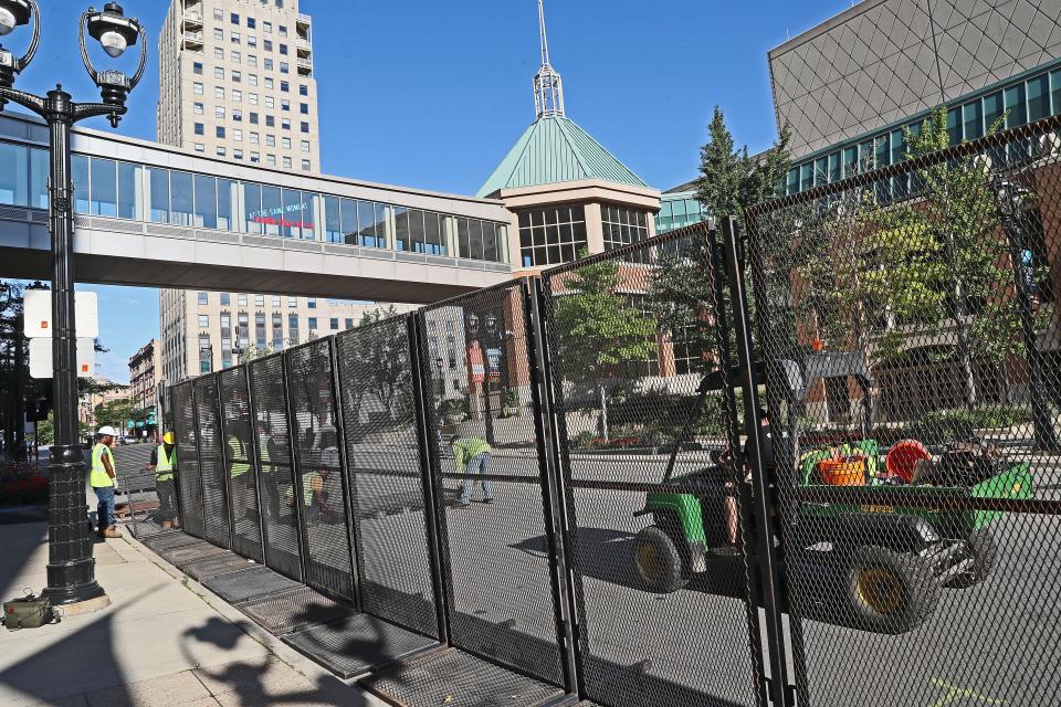Crews remove fencing along Wisconsin Avenue across from the convention center on Aug. 21, 2020, after the end of the virtual Democratic National Convention.