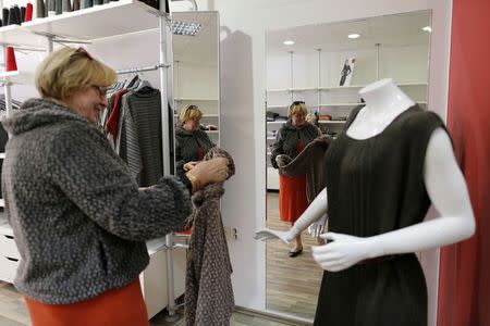 A customer looks at a piece of clothing in an Arena Modna Kuca store in the Adriatic town of Pula, July 1, 2014. REUTERS/Antonio Bronic