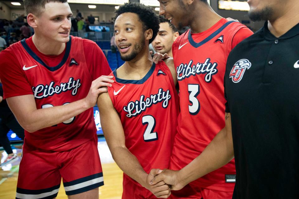 Liberty Flames guard Darius McGhee (2) celebrates with teammate after scoring a game-high 48 points to defeat the Florida Gulf Coast Eagles 78-75 in a ASUN men’s basketball game, Saturday, Jan. 15, 2022, at Alico Arena in Fort Myers, Fla.