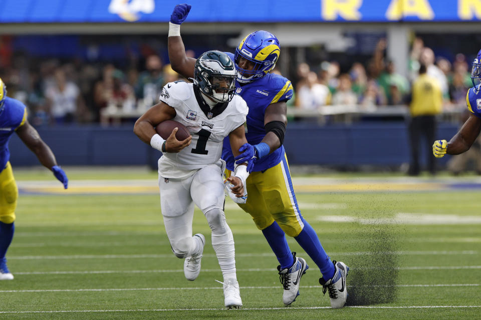 Los Angeles Rams defensive tackle Kobie Turner, right, tries to tackle Philadelphia Eagles quarterback Jalen Hurts during the second half of an NFL football game Sunday, Oct. 8, 2023, in Inglewood, Calif. (AP Photo/Kevork Djansezian)