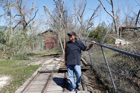 FILE PHOTO: Jim Broaddus, director of the Bear Creek Feline Center, stands on a fence flattened by Hurricane Michael at the Feline Center in Panama City, Florida, U.S. October 12, 2018. REUTERS/Terray Sylvester/File Photo