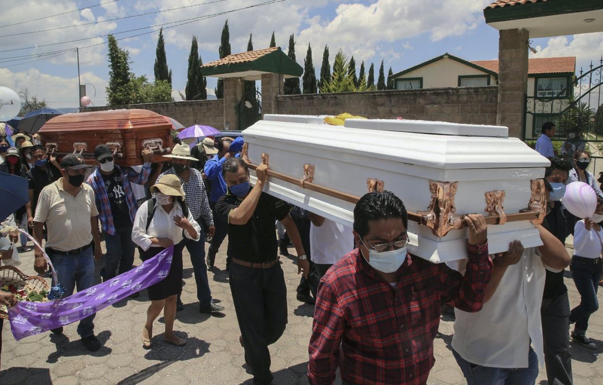 <span class="caption">Funeral for a woman and her 11-year-old daughter, both found dead inside a burnt out vehicle in Puebla state, Mexico, June 11, 2020. </span> <span class="attribution"><a class="link " href="https://www.gettyimages.com/detail/news-photo/relatives-and-friends-of-gardenia-ortega-and-her-11-year-news-photo/1221065114?adppopup=true" rel="nofollow noopener" target="_blank" data-ylk="slk:Jose Castanares/AFP via Getty Images);elm:context_link;itc:0;sec:content-canvas">Jose Castanares/AFP via Getty Images)</a></span>