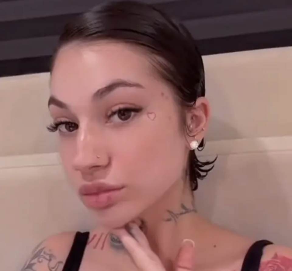 A selfie of Bhad Bhabie with tattoos and heart-shaped cheek adornment