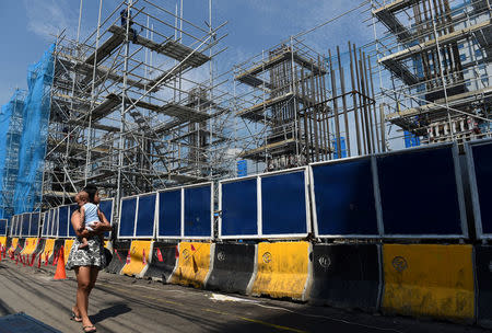 A woman carrying a baby passes though a construction of the Metro Rail Transit (MRT) on Commonwealth Avenue in Quezon City, metro Manila, May 23, 2018. REUTERS/Dondi Tawatao