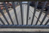 A man crosses an empty road following the lockdown by the government amid concerns about the spread of coronavirus disease (COVID-19) outbreak, in Kathmandu