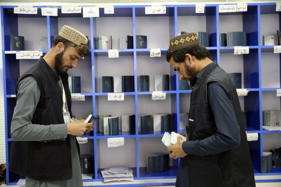 Workers arranges passports in the main post office in the city of Kabul, Afghanistan, Wednesday, July 3, 2024. In parts of Afghanistan where there are no street names or house numbers, utility companies and their customers have adopted a creative approach for connecting. They use mosques as drop points for bills and cash, a "pay and pray" system. (AP Photo/Siddiqullah Alizai)