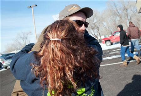 Ernie Carmichael, of Lovelock, hugs Chris Montes (R) after hearing that Montes was one of the rescuers that found a family in a remote mountain range northeast of Reno, in Lovelock, Nevada, December 10, 2013. REUTERS/James Glover