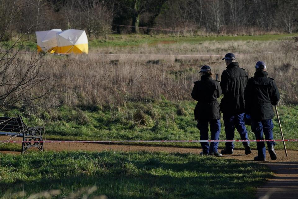 Forensic tents and a police search team at the scene at Hanworth Park, Feltham (PA)