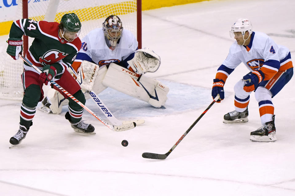 New Jersey Devils left wing Miles Wood (44) sets up in front of New York Islanders goaltender Semyon Varlamov (40) with Islanders defenseman Andy Greene (4) nearby during the third period of an NHL hockey game Tuesday, March 2, 2021, in Newark, N.J. (AP Photo/Kathy Willens)