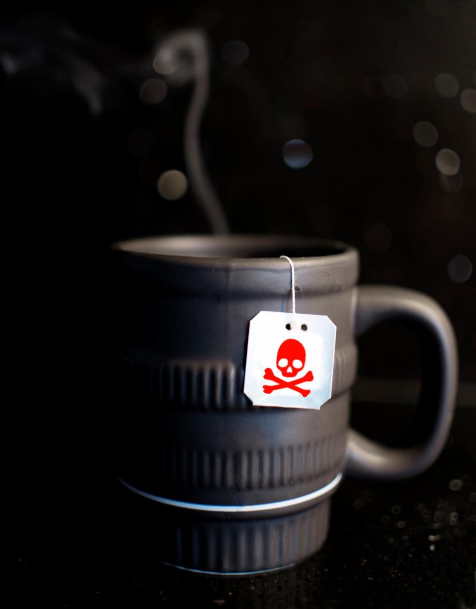 Close-up of a mug with a teabag with a skull and crossbones on it