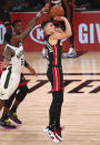 Miami Heat guard Tyler Herro (14) shoots as Milwaukee Bucks guard Eric Bledsoe (6) moves in on defense during the first half of an NBA basketball game Thursday, Aug. 6, 2020, in Lake Buena Vista, Fla. (Kim Klement/Pool Photo via AP)