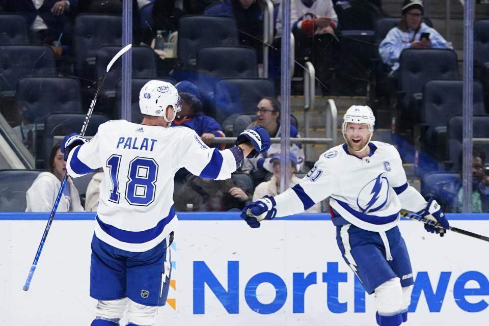 Tampa Bay Lightning's Steven Stamkos, right, celebrates with teammate Ondrej Palat (18) after scoring a goal during the third period of an NHL hockey game against the New York Islanders, Friday, April 29, 2022, in Elmont, N.Y. (AP Photo/Frank Franklin II)