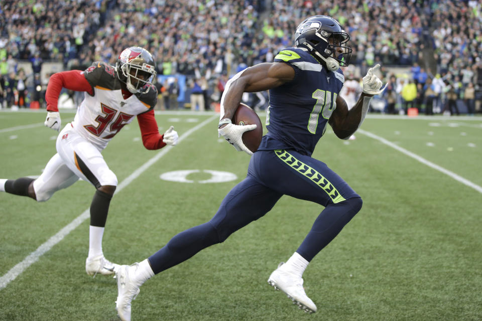 FILE - Seattle Seahawks wide receiver DK Metcalf, right, runs to score a touchdown ahead of Tampa Bay Buccaneers defensive back Jamel Dean during the second half of an NFL football game in Seattle, in this Sunday, Nov. 3, 2019, file photo. Seahawks wide receiver DK Metcalf is explosive off the line of scrimmage. But Sunday, May 9, 2021, he will venture into a new sort of lane to test his speed on a different sort of line, one that's filled with Olympic-caliber sprinters. (AP Photo/Scott Eklund, File)