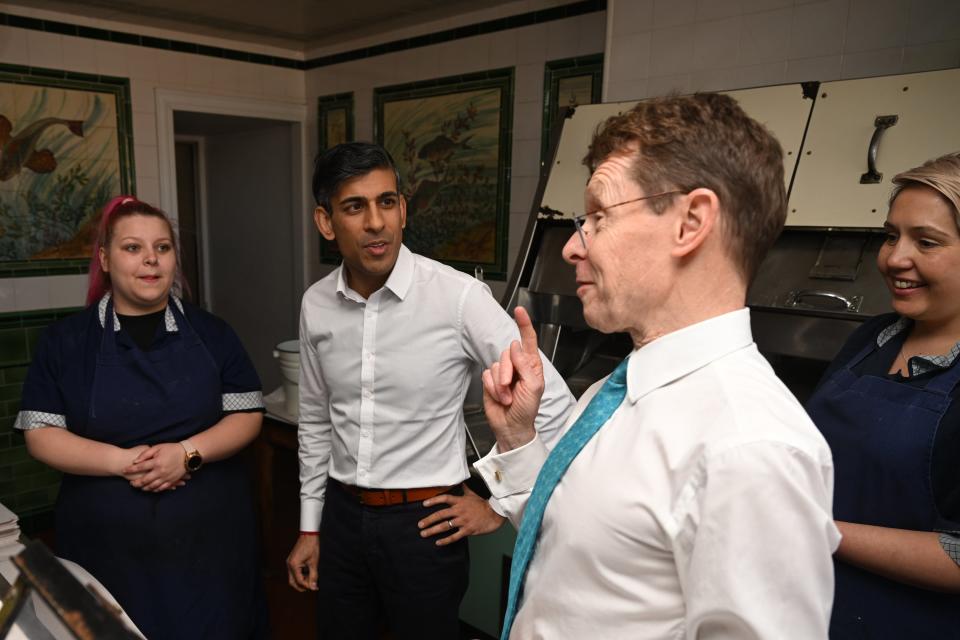 Sunak listens to Mayor Street as they visit a fish and chip shop (Getty)