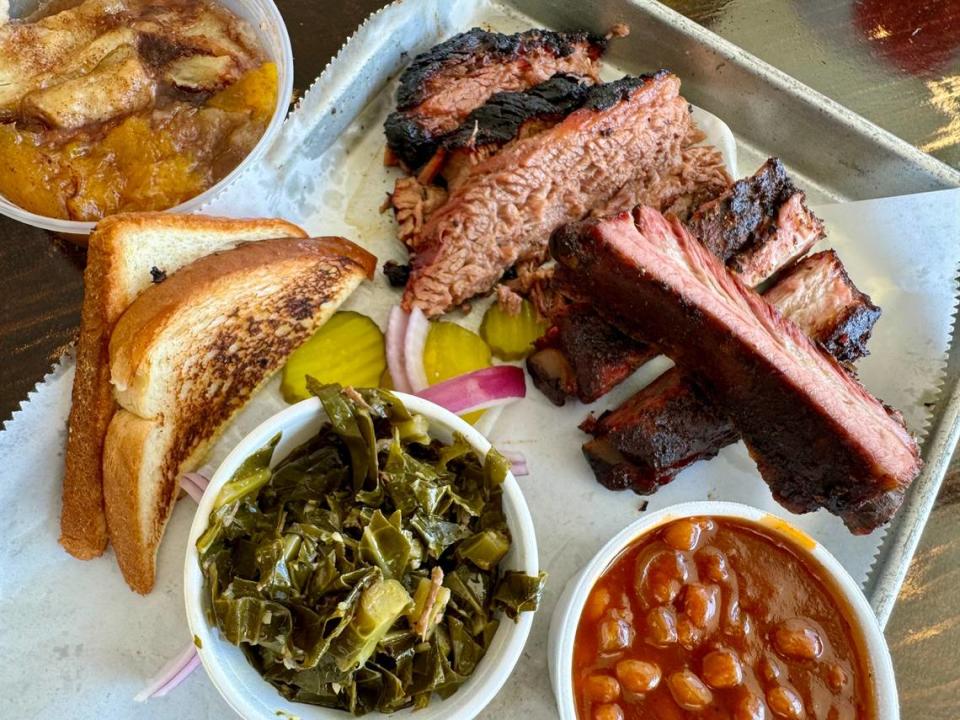 A traditional barbecue plate with brisket, ribs, collard greens and peach cobbler at Smoke ‘N Ash BBQ in Arlington.