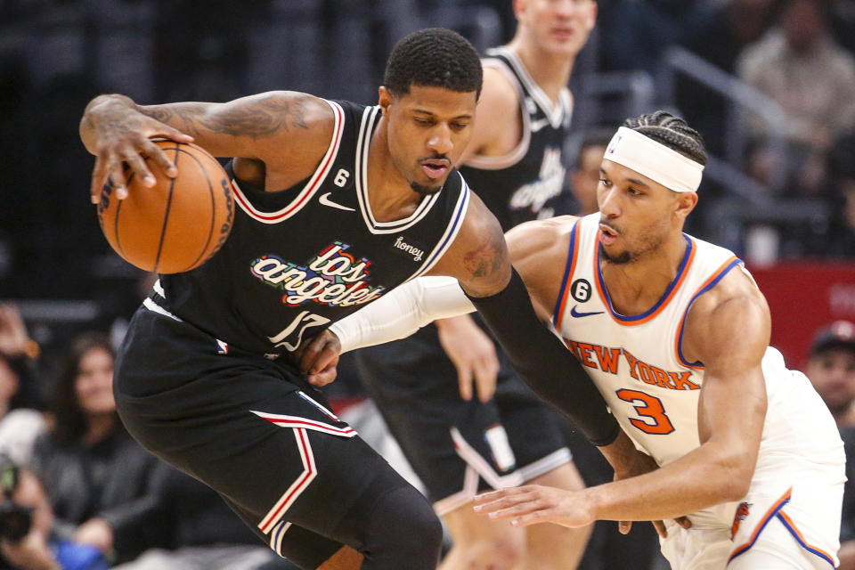 Los Angeles Clippers forward Paul George, left, is defended by New York Knicks guard Josh Hart during the first half of an NBA basketball game Saturday, March 11, 2023, in Los Angeles. (AP Photo/Ringo H.W. Chiu)