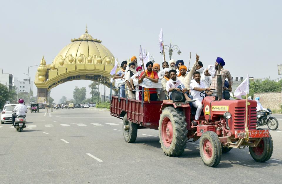 AMRITSAR, INDIA SEPTEMBER 25: Farmers onboard a tractor shout slogans during Punjab Bandh, a statewide farmers' strike, against the passing of agriculture bills in the Parliament, at Golden gate, on September 25, 2020 in Amritsar, India. The two bills - the Farmers (Empowerment and Protection) Agreement on Price Assurance and Farm Services Bill, 2020 and the Farming Produce Trade and Commerce (Promotion and Facilitation) Bill, 2020 - were passed by the Rajya Sabha despite uproar and strong protest by the Opposition parties in the house. (Photo by Sameer Sehgal/Hindustan Times via Getty Images)