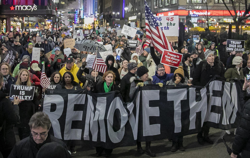 An anti-President Trump crowd gather at a rally to protest and call for his impeachment, Tuesday Dec. 17, 2019, in New York. (AP Photo/Bebeto Matthews)