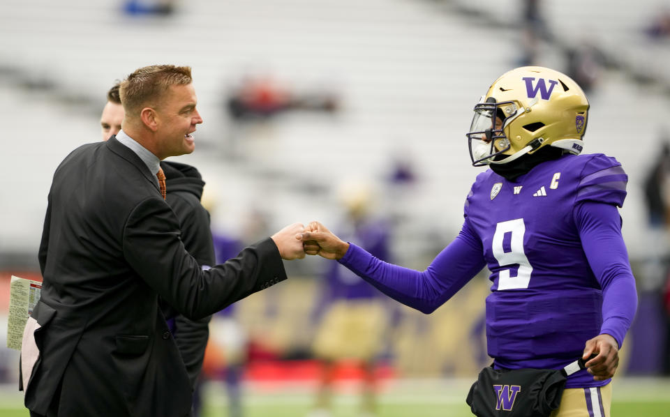 Former NFL and Washington quarterback Brock Huard, left, greets Washington quarterback Michael Penix Jr., right, before an NCAA college football game against Utah, Saturday, Nov. 11, 2023, in Seattle. The final football season for the Pac-12 with its current membership is coming to a thrilling conclusion. The conference wraps up regular-season play this week before the title game in Las Vegas on Dec. 1, 2023. Washington and Oregon still have hopes of getting the Pac-12 its first College Football Playoff berth since 2016. (AP Photo/Lindsey Wasson)