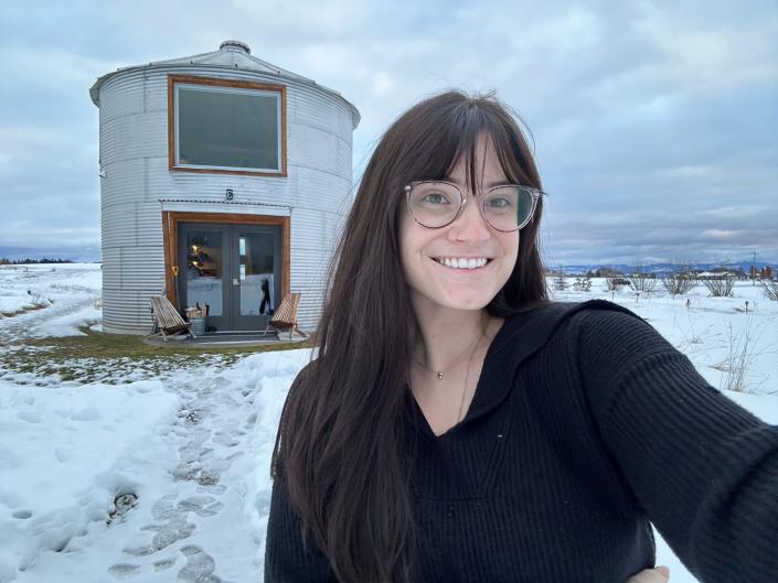 The author takes a selfie in front of a grain silo turned Airbnb in Montana.