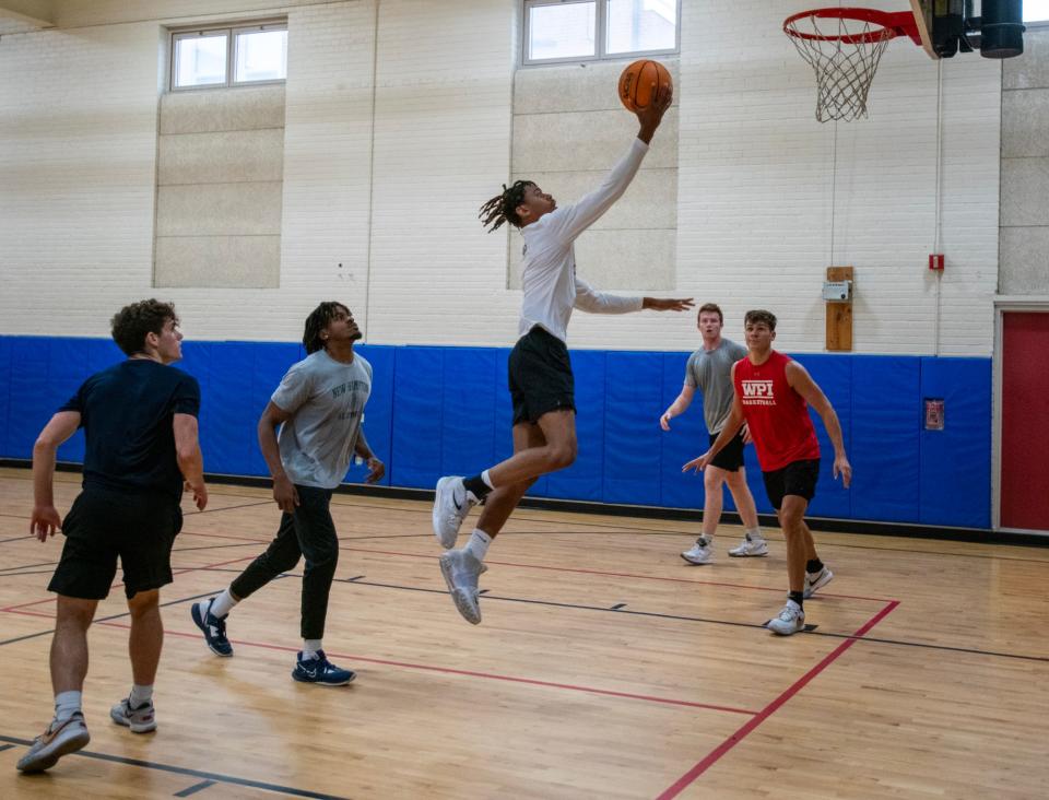 Chris Clarke leaps to the basket during a pickup basketball league game Monday at Mills Town Hall.