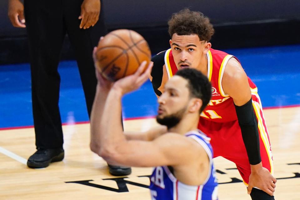 Hawks guard Trae Young, right, watches as 76ers' Ben Simmons attempts a free throw Wednesday night in Philadelphia.