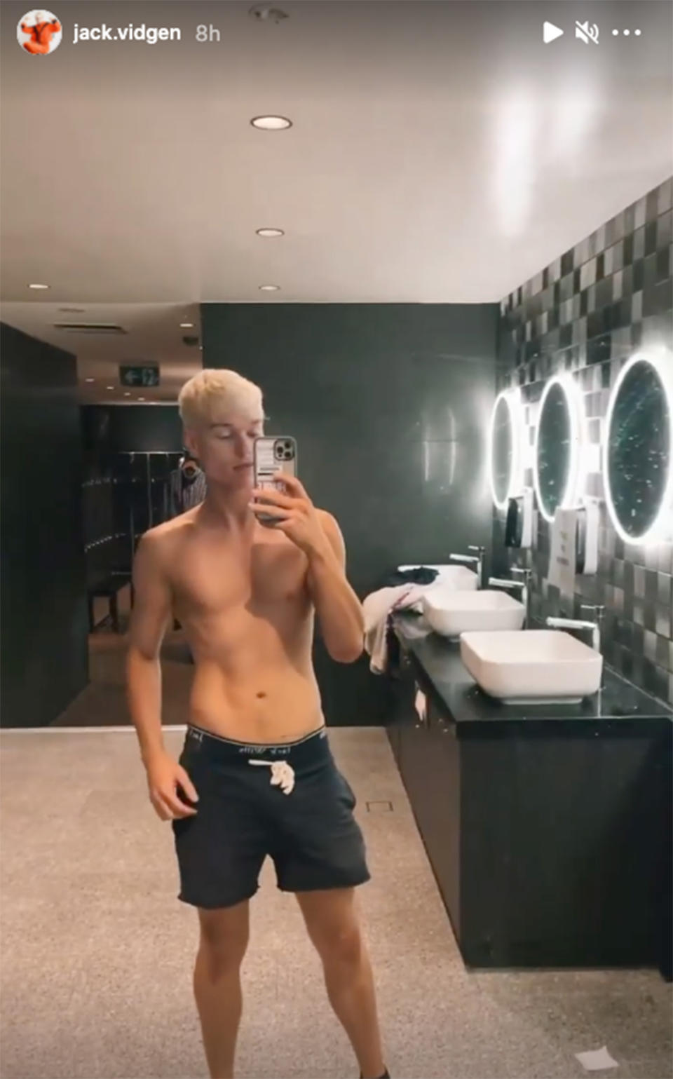 Jack Vidgen takes a shirtless mirror selfie in a gym locker room