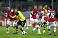 Borussia Dortmund's Jakub Blaszczykowski (2nd L) is challenged by Arsenal's Mikel Arteta (L) during their Champions League Group F soccer match in Dortmund November 6, 2013. REUTERS/Ina Fassbender (GERMANY - Tags: SPORT SOCCER)