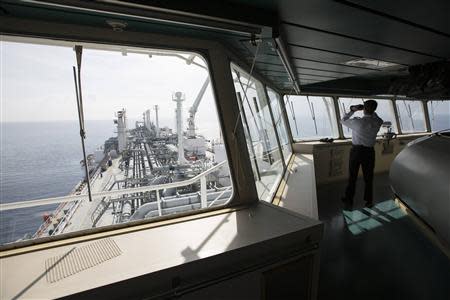 An officer uses binoculars as he stands on a tanker carrying liquefied natural gas in the Mediterranean, some 10 km (6 miles) from the coastal Israeli city of Hadera in this January 22, 2014 file picture. REUTERS/Baz Ratner/Files