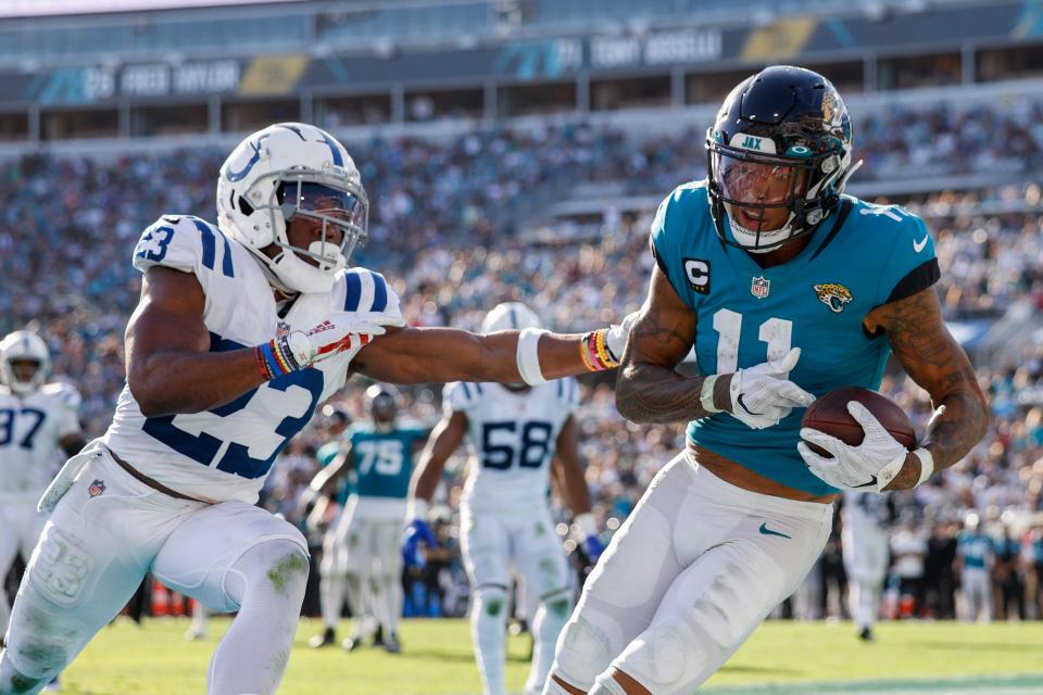 Jan 9, 2022; Jacksonville, Florida, USA;  Jacksonville Jaguars wide receiver Marvin Jones (11) catches a pass for a touchdown  defended by Indianapolis Colts cornerback Kenny Moore II in the second half at TIAA Bank Field. Mandatory Credit: Nathan Ray Seebeck-USA TODAY Sports