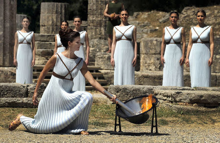 Greek actress Katerina Lehou , playing the role of High Priestess, lights a torch from the sun's rays reflected in a parabolic mirror during the dress rehearsal for the Olympic flame lighting ceremony for the Rio 2016 Olympic Games at the site of ancient Olympia in Greece. REUTERS/Yannis Behrakis