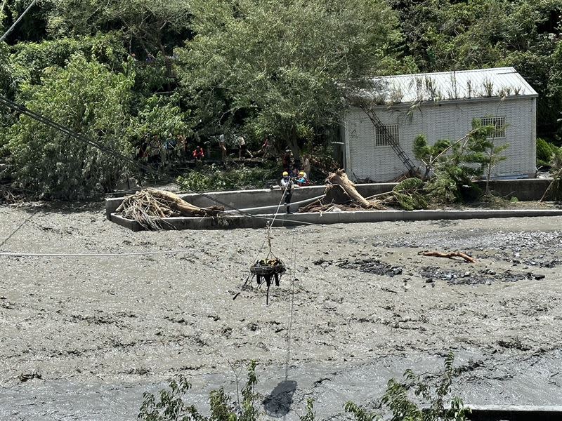 廬山溫泉區80多人受困，救難人員架繩索輸送物資、後送人員，下方就是滾滾泥水。（圖／消防署提供）
