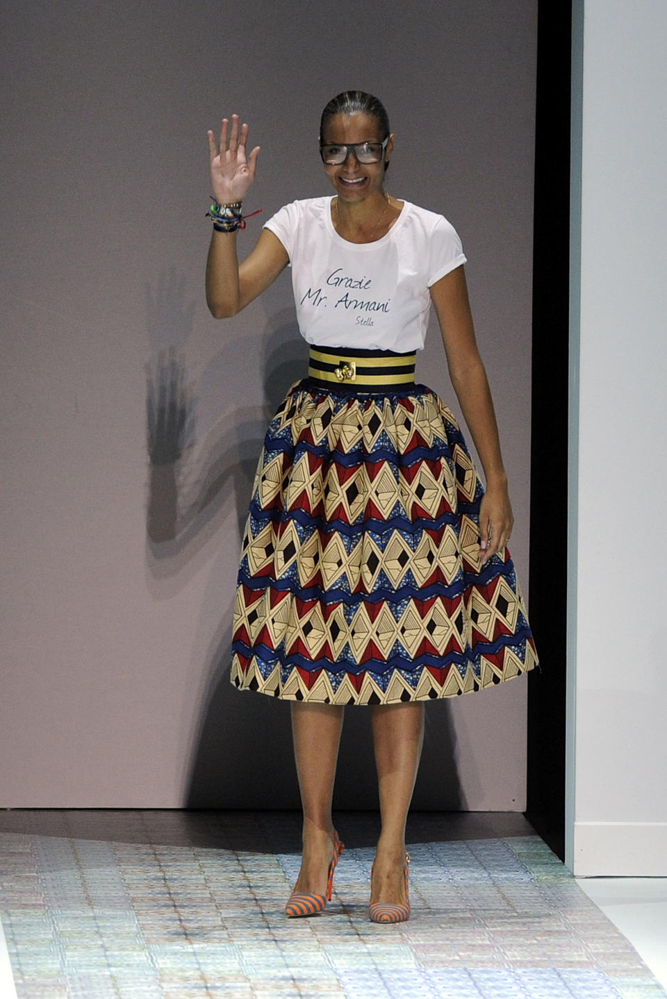 Designer Stella Jean acknowledges the audience as she wears a shirt with writing in Italian reading "Thank you Mr. Armani", at the end of her women's Spring-Summer 2014 collection, part of the Milan Fashion Week, unveiled in Milan, Italy, Saturday, Sept. 21, 2013. Renowned Italian designer Giorgio Armani hosted the fashion show of emerging designer Stella Jean at the Armani Theater, his show space. (AP Photo/Giuseppe Aresu)