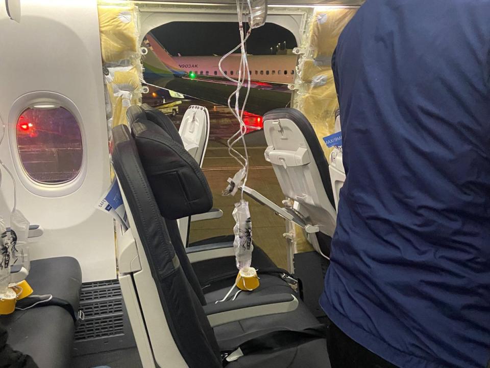 Passenger oxygen masks hang from the roof next to a missing window and a portion of a side wall of an Alaska Airlines Flight 1282 (Kyle Rinker/Reuters)