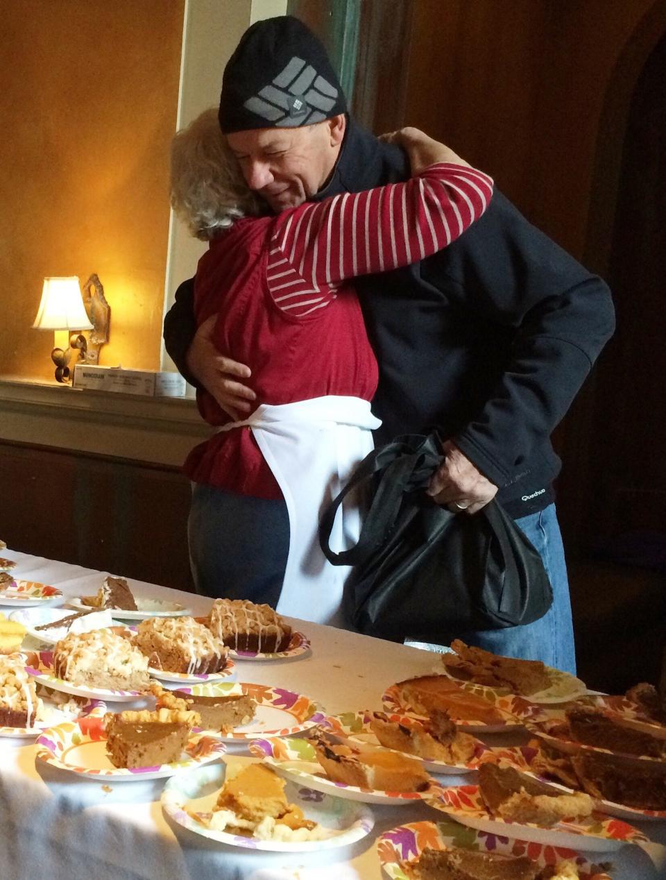 Emmanuel Tissot, 70, of Jericho, hugs Anna Deller, 80, of South Burlington after dropping off an apple pie for the free Thanksgiving meal at Sweetwaters American Bistro on Church Street in Burlington on Thursday, November 24, 2015.