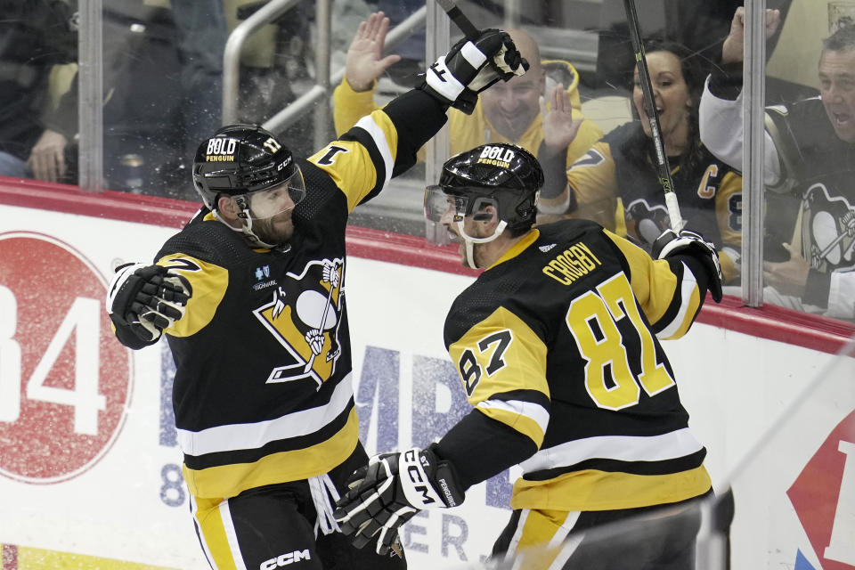 Pittsburgh Penguins' Bryan Rust (17) celebrates his goal with Sidney Crosby during the first period of an NHL hockey game against the Boston Bruins in Pittsburgh, Saturday, April 1, 2023. (AP Photo/Gene J. Puskar)