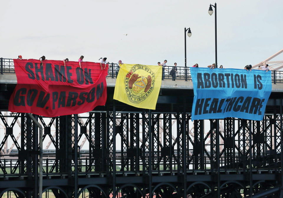 Abortion-rights activists hang banners on the Eads Bridge in St. Louis during a Planned Parenthood press conference on the north end of the Arch grounds on Friday, June 28, 2019. A Missouri commissioner on Friday ruled that the state's only abortion clinic can continue providing the service at least until August as a fight over its license plays out, adding that there's a "likelihood" that the clinic will succeed in the dispute. (David Carson/St. Louis Post-Dispatch via AP)