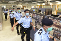 Police officers take action inside Apple Daily headquarters as Hong Kong media tycoon Jimmy Lai, who founded local newspaper Apple Daily, is arrested by police officers at his home in Hong Kong, Monday, Aug. 10, 2020. Hong Kong police arrested Lai and raided the publisher's headquarters Monday in the highest-profile use yet of the new national security law Beijing imposed on the city after protests last year. (Apple Daily via AP)