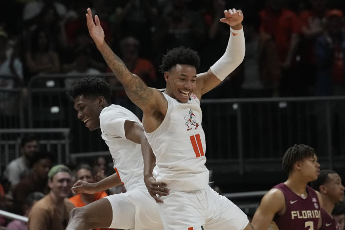 Miami guard Jordan Miller (11) and forward Anthony Walker (1) celebrate after Walker dunked the ball during the first half of an NCAA college basketball game against Florida State, Saturday, Feb. 25, 2023, in Coral Gables, Fla. (AP Photo/Marta Lavandier)