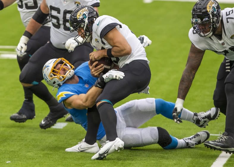 INGLEWOOD, CA - OCTOBER 25: Chargers defensive end Joey Bosa, left, assists in sacking Jaguars quarterback Gardner Minshew II, center, in the first half amid an empty SoFi Stadium on Sunday, Oct. 25, 2020 in Inglewood, CA. Chargers beat the Jaguars 39-29. (Allen J. Schaben/Los Angeles Times)