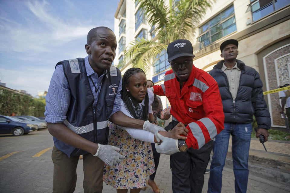 A civilian is helped by paramedics at a hotel complex in Nairobi, Kenya Tuesday, Jan. 15, 2019. Terrorists attacked an upscale hotel complex in Kenya's capital Tuesday, sending people fleeing in panic as explosions and heavy gunfire reverberated through the neighborhood. (AP Photo/Ben Curtis)