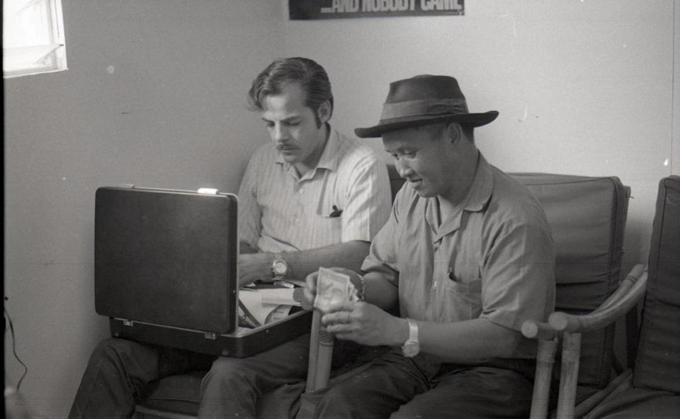 In this image, “USAID Personnel #12,” Galen Beery (USAID) is photographed working next to Naikhong Zueker Moua (USAID) in Ban Xon, Laos in 1971.