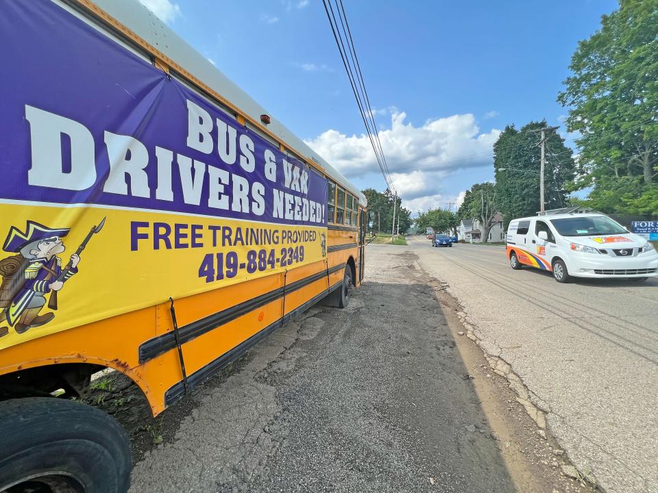 A Lexington school bus outside of Central Elementary advertises jobs for van and bus drivers.