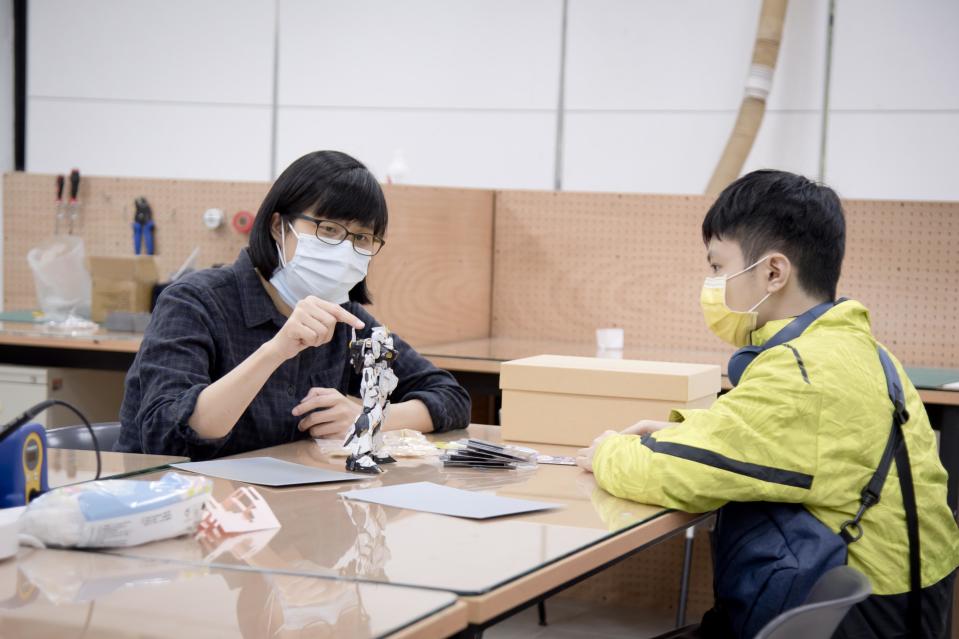華梵大學自主學習學生陳家驊（右）在個人工作空間與老師討論機器人作品 (華梵提供)