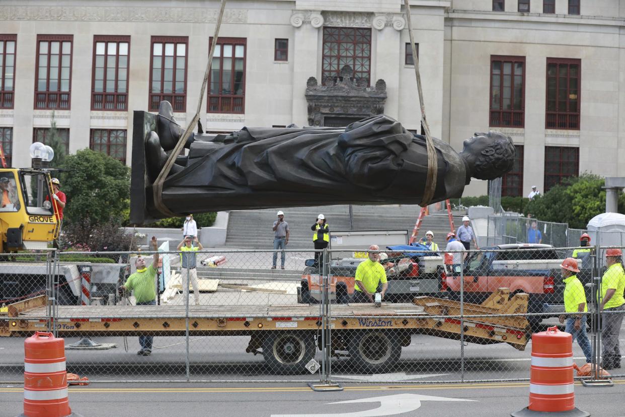 Workers remove the Christhopher Columbus statue on the Broad St. side of Columbus City Hall on Wednesday, July 1, 2020, in Columbus, Ohio. The city says it will be replaced with a different statue or artwork that reflects diversity. A city news release said it will be placed in safekeeping at a secure city facility. The Christopher Columbus statue was a gift from the people of Genoa, Italy in 1955.