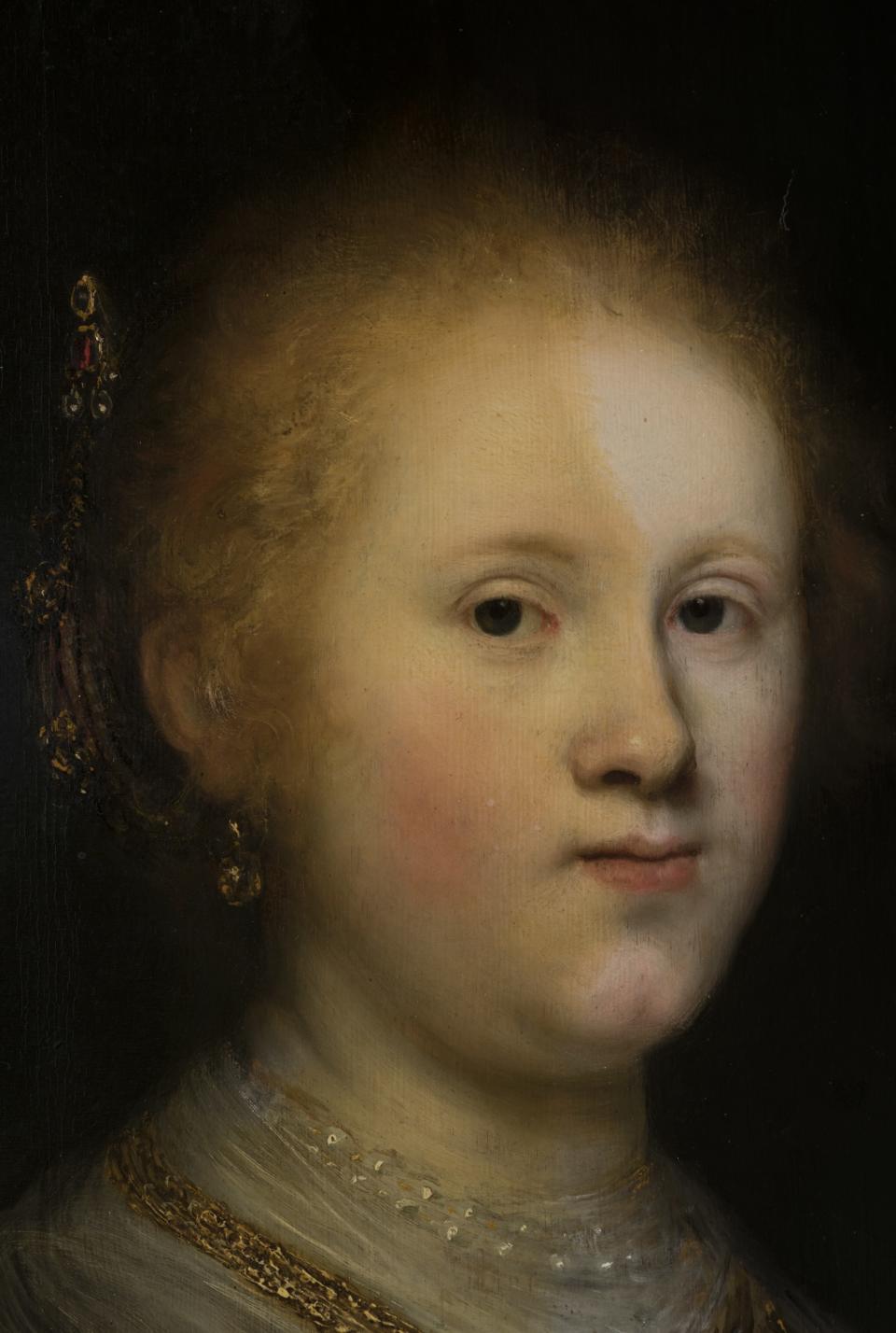 A photograph of the portrait mid-restoration shows the extent of the layers of varnish (left side) and what the work looked like when it was first painted (right side).