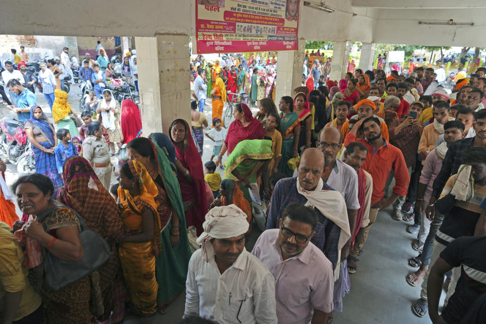 People stand in queue to register outside district hospital in Ballia, Uttar Pradesh state, India, Monday, June 19, 2023. Several people have died in two of India's most populous states in recent days amid a searing heat wave, as hospitals find themselves overwhelmed with patients. More than hundred people in the Uttar Pradesh and dozens in neighboring Bihar have died due to heat-related illness. (AP Photo/Rajesh Kumar Singh)