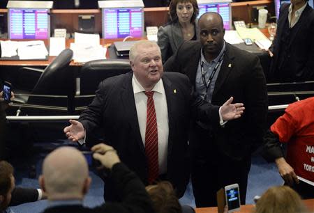 Toronto Mayor Rob Ford (C) reacts after walking around council chambers while an unidentified member of his staff captured images of the public gallery during a special council meeting at City Hall in Toronto November 18, 2013. REUTERS/Aaron Harris